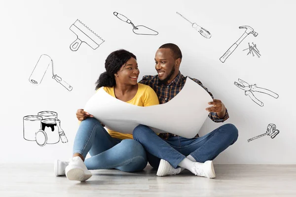 Творческий коллаж для ремонта семейного дома. Веселая черная пара проверяет чертежи вместе — стоковое фото