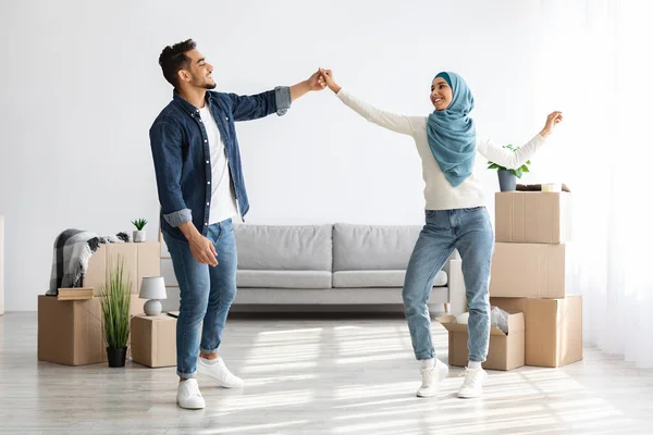 Vidám közel-keleti férfi és nő táncol az új lakásban — Stock Fotó