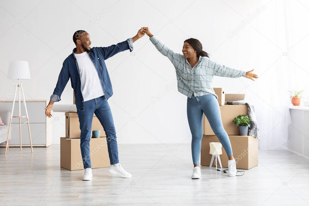 Moving Day. Joyful African American Spouses Dancing In Their New Apartment