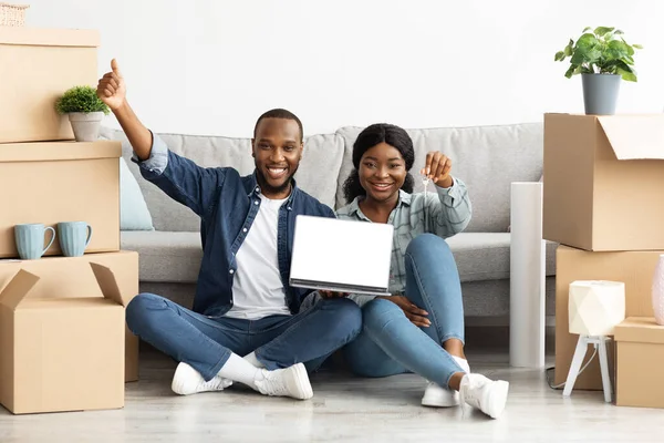 Mutlu Siyah Çift Ev Anahtarlarını Tutuyor ve Boş Ekranlı Dizüstü Bilgisayarı Gösteriyor — Stok fotoğraf