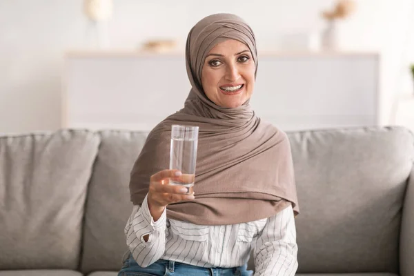 Donna musulmana posa tenendo vetro di acqua potabile a casa — Foto Stock