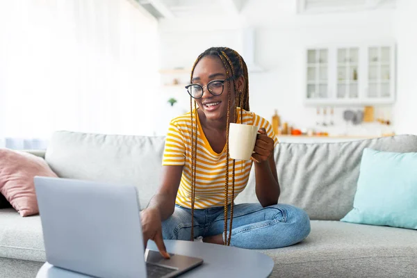 Mulher negra bonita à procura de filme online — Fotografia de Stock