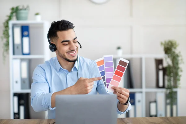 Arabische man toont kleurstalen op laptop op kantoor, presentatie grafisch ontwerp project tijdens externe zakelijke bijeenkomst — Stockfoto