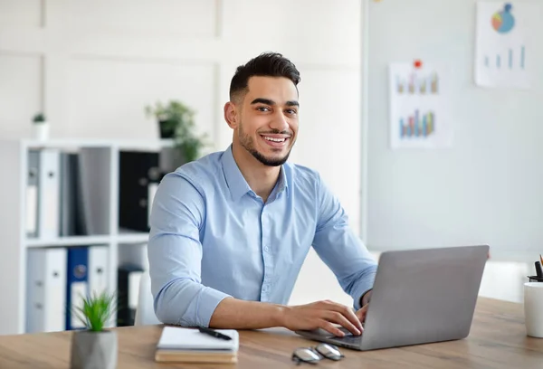 Attraktiver junger arabischer Geschäftsmann nutzt Laptop am Schreibtisch im Home Office — Stockfoto