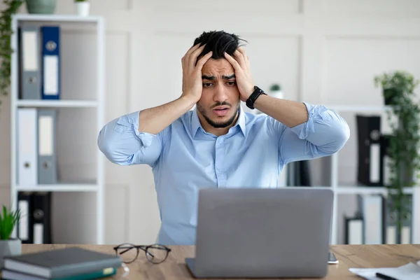 Uomo d'affari arabo disperato che ha troppo lavoro, commettendo errori, non riesce a rispettare la scadenza, soffre di mal di testa al lavoro — Foto Stock