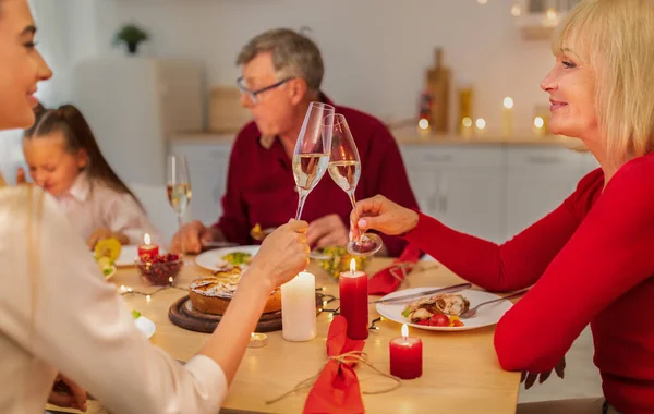 Fiatal nő és idősebb anya pohárköszöntő borospohárral, ünnepli nyaralás a családdal, élvezi ünnepi vacsora — Stock Fotó