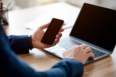 İnternet sitesi veya uygulama tasarımı için dizüstü bilgisayar ve cep telefonu kullanan tanınmayan Arap işadamı, kırpıldı