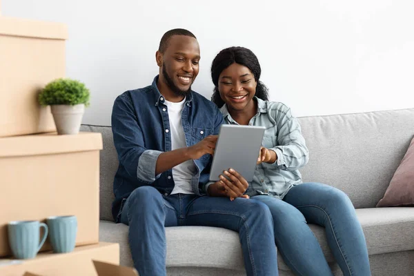 Schwarzes Paar bestellt nach Umzug in neue Wohnung online mit digitalem Tablet — Stockfoto