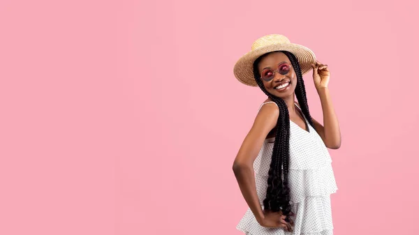 Mujer negra juguetona con racimos afro mirando a un lado en el espacio libre sobre fondo de estudio rosa, panorama — Foto de Stock