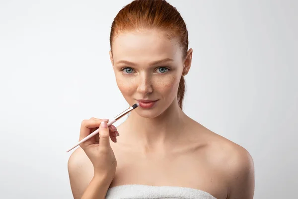 Female Arm Making Makeup For Red-Haired Female Model, Gray Background — Stock Photo, Image