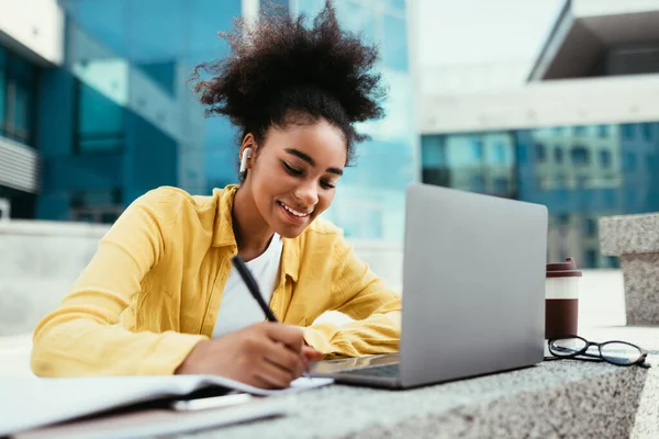Leende svart student flicka på laptop tar anteckningar lärande utomhus — Stockfoto
