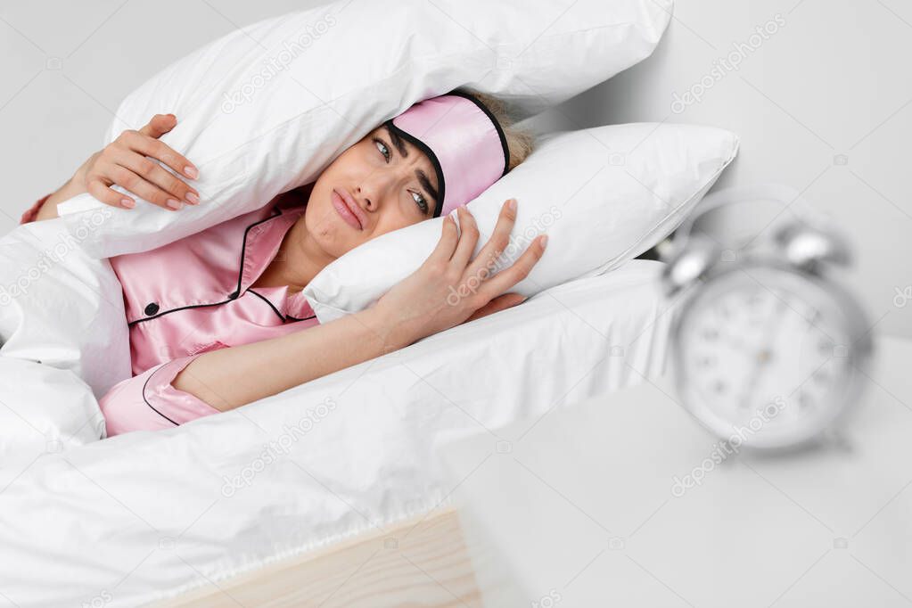 Frustrated lady hates alarm clock, tired sleepy woman does not want to get up