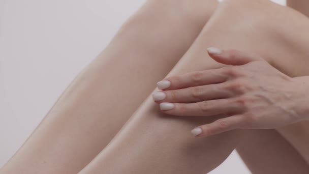 Предотвращение варикоза. Крупный план женских ног, неузнаваемая женщина наносит крем против варикоза на кожу лодыжки — стоковое видео