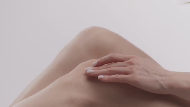 Подбайте про суглоби. Крупним планом знімок невизначеної жінки, що наносить лікувальний крем на коліна, страждає від болю в ногах — стокове відео
