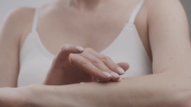 Przeciwstarzeniowa pielęgnacja skóry. Młoda, nierozpoznana biała dama nakładająca trzy kropki rozpieszczającego kremu na dłoń — Wideo stockowe
