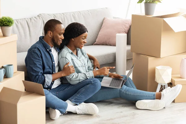 Онлайн-заказ. Молодая черная пара с ноутбуком, покупка мебели в Интернете — стоковое фото