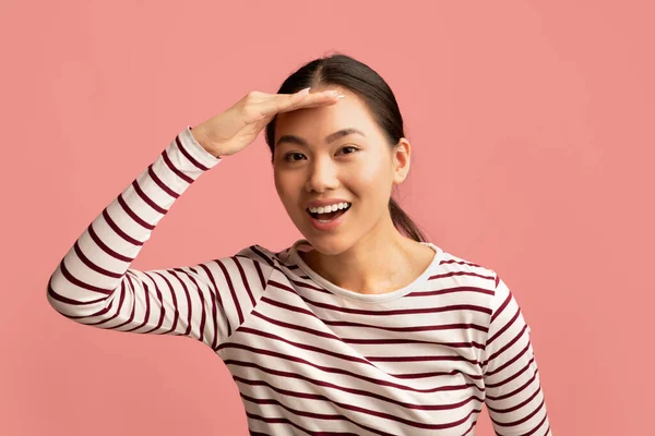 Asijské žena udržet ruku v blízkosti čela a při pohledu na kameru s úrokem — Stock fotografie