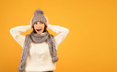 Bu inanılmaz. Sıcak süveter ve örgü ören genç bayan satışları görünce şok oluyor, sarı arka plan.