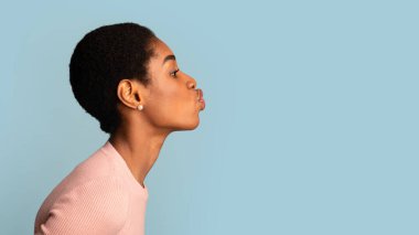 Mavi Stüdyo Arkaplanı Üzerine Dudaklarını Sokan Genç Siyah Kadın Görünümü