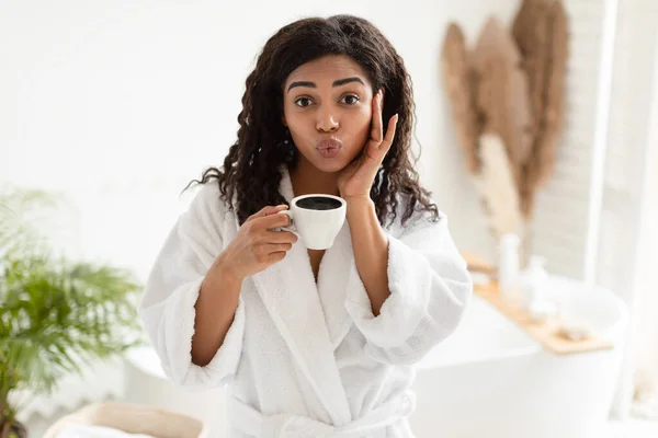 Afrikai nő kávézás és duzzogó ajkak pózol a fürdőszobában — Stock Fotó