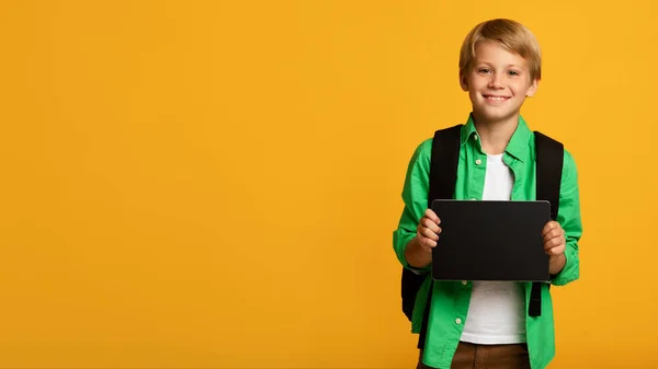 Счастливый блондин-подросток, белый ученик показывает планшет с пустым экраном — стоковое фото