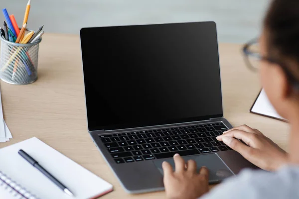 Adolescente afro-americano menina pupila em óculos digitando no laptop com tela em branco — Fotografia de Stock