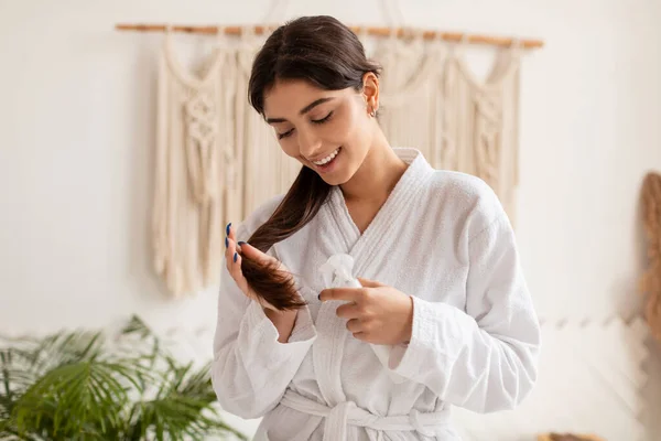 Feliz morena mulher usando laca cuidados para dividir-termina no banheiro — Fotografia de Stock