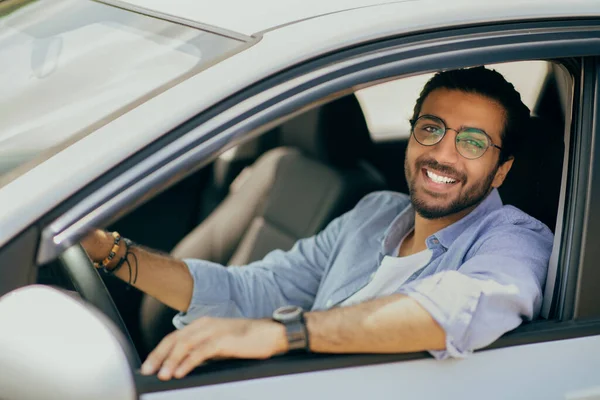 Porträt eines glücklichen Arabers, der in einem brandneuen Auto sitzt — Stockfoto