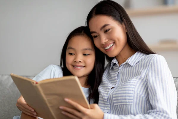 Familie blijft thuis hobby 's. gelukkig aziatische moeder en haar schattig dochter lezen boek samen thuis — Stockfoto