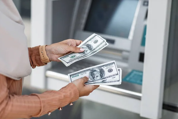 Az elégedett hölgy készpénz bankjegyeket tart a kezében az ATM közelében. Szerencsés pénz. Készpénzpont — Stock Fotó