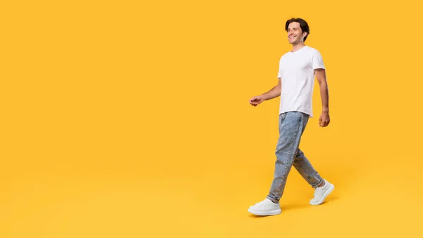 Giovane uomo barbuto camminare isolato su sfondo giallo — Foto Stock