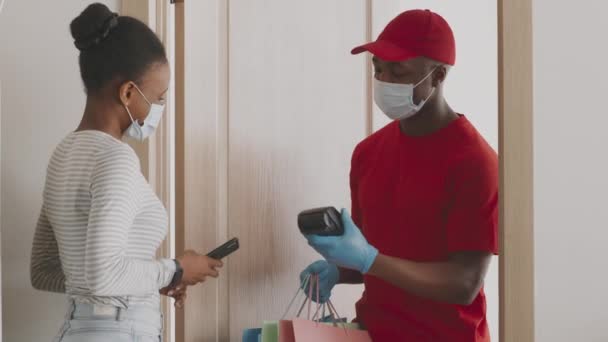 Compras online seguras e serviço de entrega. Jovem afro-americana pagando por ordem de roupas com aplicativo para smartphone — Vídeo de Stock