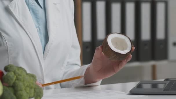 Arzt Ernährungsberater zeigt Kokosnuss als Kuhmilchersatz, spricht mit Patienten mit Laktoseintoleranz, Kamerafahrt — Stockvideo