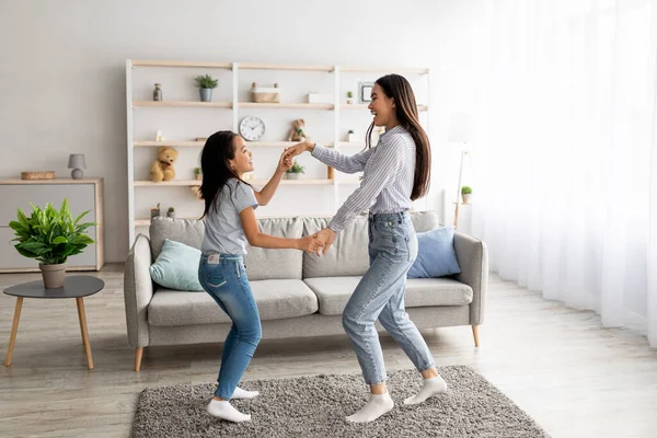 Alegre asiática mamá y hija bailando a la música, tomados de la mano y disfrutando de la canción favorita juntos en casa —  Fotos de Stock