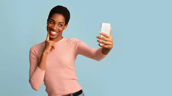 Akıllı telefondan selfie çeken, kameraya gülümseyen sevimli siyah kadın. — Stok fotoğraf