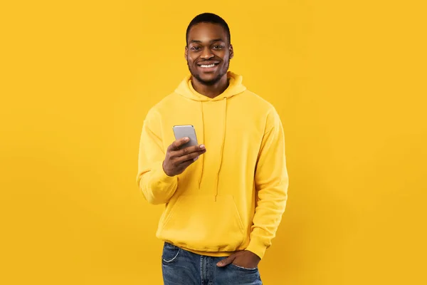 Happy Black Millennial Man Mobiltelefon használata sárga háttér — Stock Fotó