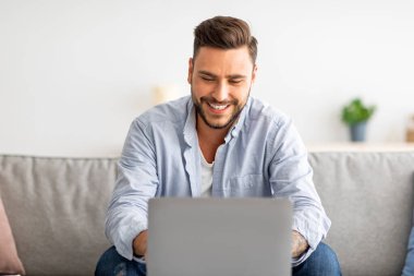 İşe alım konsepti. Mutlu milenyum adamı internette iş fırsatlarını araştırıyor, iş arama sitesini dizüstü bilgisayarında kullanıyor.