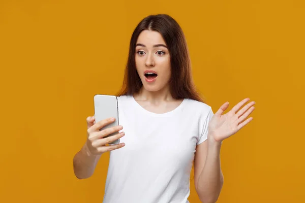Geschokt mooie dame op zoek naar mobiele telefoon scherm — Stockfoto