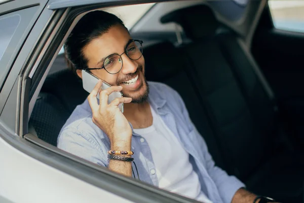 Fröhlicher indischer Mann sitzt im Taxi und telefoniert — Stockfoto