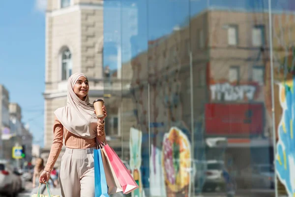 Renkli alışveriş torbalarıyla tesettürlü, mutlu, güzel, Arap bir kadın. — Stok fotoğraf