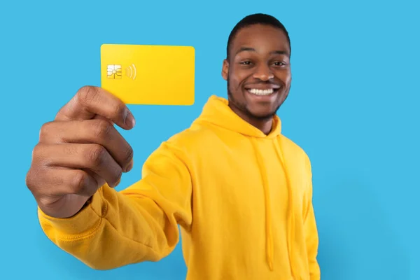 African American Man Wyświetlanie karty kredytowej na niebieskim tle Studio — Zdjęcie stockowe