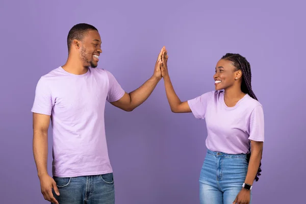 Porträt eines glücklichen schwarzen Paares, das mit High Five den Sieg feiert — Stockfoto