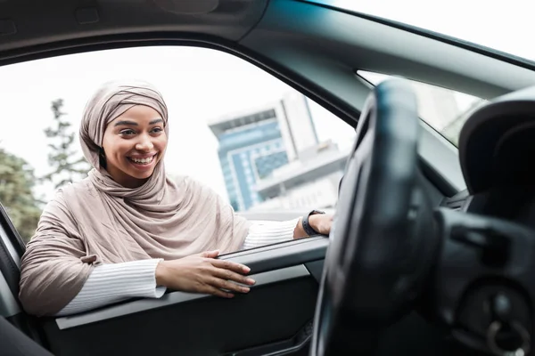 Feliz atractivo musulmán afroamericano mujer comprador mira en el salón de nuevo coche de ventana abierta — Foto de Stock