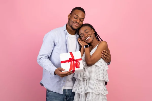 Feliz hombre negro haciendo sorpresa para mujer dando caja — Foto de Stock