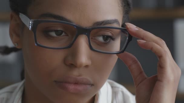 Melancolia no local de trabalho. Close up retrato de triste jovem afro-americano senhora trabalhador de escritório fixando seus óculos no rosto — Vídeo de Stock