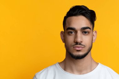 Sarıya poz veren çekici sakallı Arap adam.