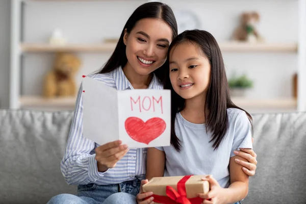 Szczęśliwy Azji kochający córka pozdrowienia mama z Dzień Matki, młoda kobieta gospodarstwa i czytania karty ręcznie — Zdjęcie stockowe