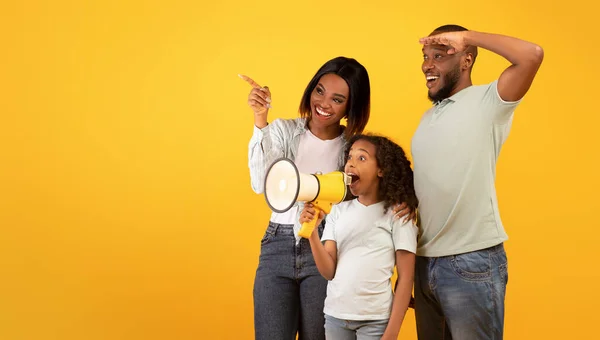 Gelukkig Afrikaans amerikaanse familie van drie maken aankondiging, meisje praten op luidspreker en kijken naar kopieerruimte — Stockfoto