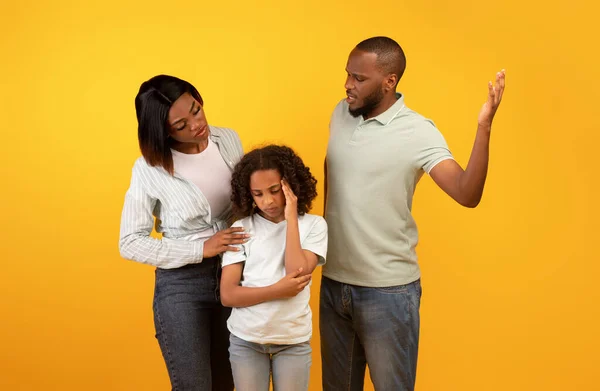 Young black father shouting at daughter and mother comforting upset little girl, hugging and consoling her — ストック写真