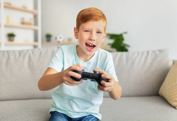 Emotionaler Rotschopf mit Joystick, der Videospiel spielt — Stockfoto